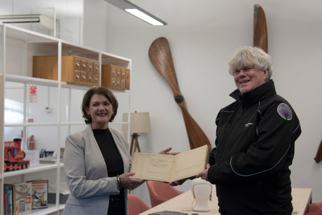 Auckland Airports Anna Cassels Brown presents Jean Battens logbook to MOTAT chief executive Michael Frawley